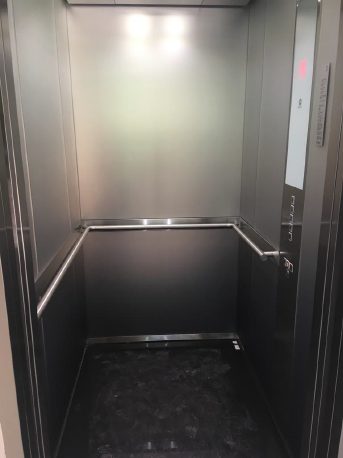 Cabina de elevador con pasamanos y acabado en acero inoxidable